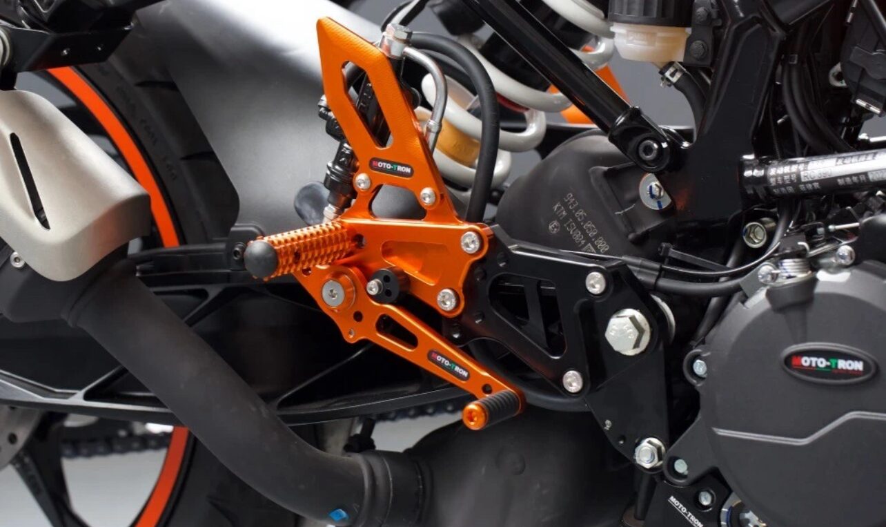 Orange MOTO-TRON rear set installed on a KTM motorcycle